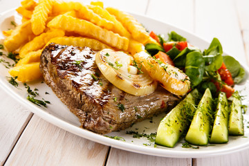 Grilled steak, French fries and vegetables 