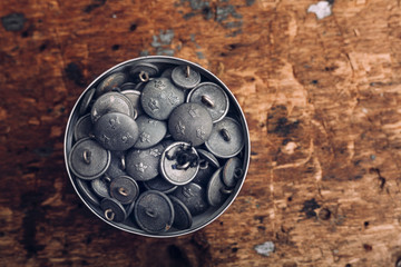 Directly above shot of jar filled with buttons on table at workshop