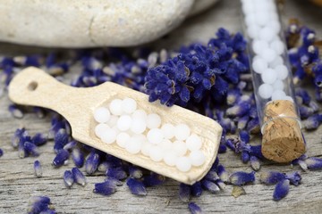 Globuli mit Lavendel und Holzlöffel