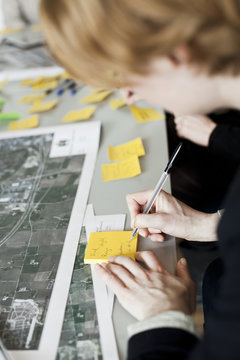 Cropped image of businessman writing on adhesive note in office