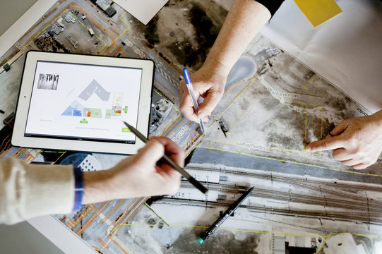 Cropped image of man with pens discussing over street map