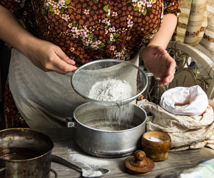 
Woman preparing dough basis.Ingredients for baking.Female hands spilling powder on dough.Making dough by female hands.Cooking and baking concept
