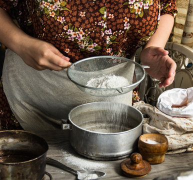 
Woman preparing dough basis.Ingredients for baking.Female hands spilling powder on dough.Making dough by female hands.Cooking and baking concept
