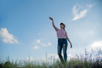 Fototapeta premium A woman in a field in the sky