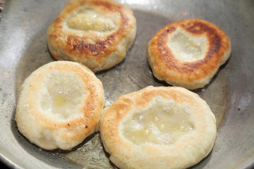 Cooking four pieces of fried bhatura in pan