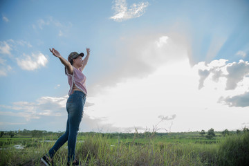 Fototapeta premium A woman in a field in the sky