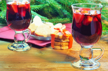 Mulled wine with cinnamon sticks and christmas bell-formed cookies