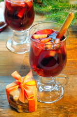 Mulled wine with cinnamon sticks and christmas bell-formed cookies