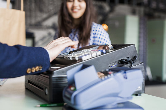 Cashier making bill for female customer in jeans factory