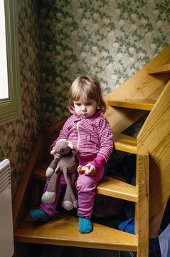 Sad girl sitting on wooden stairs