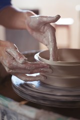 Close-up of female potter making pot