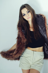 Portrait of attractive stylish woman in fur against grey background.