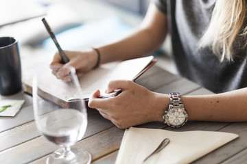 Midsection of woman writing in book