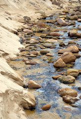 Sandstone boulders in a sandy freshwater creek