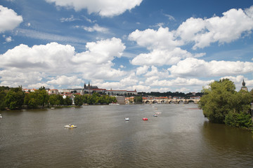 Naklejka premium Rest on the Vltava river in the summer. View of Prague Castle and Charles Bridge