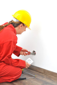 Close up of woman electrician fixing socket