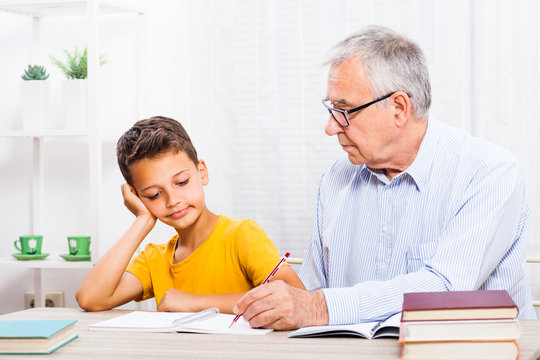 Grandfather Is Teaching His Grandson At Home.