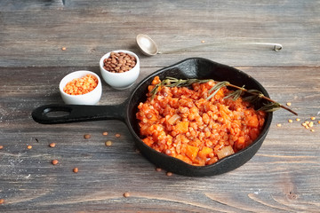 Frying lentil, carrot and onions - ingredient for lentil soup - in cast iron pan