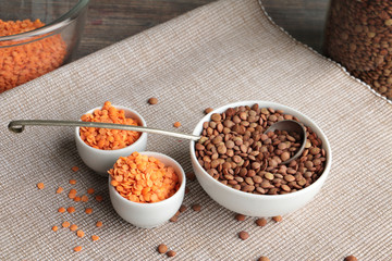 Red and brown lentil in white bowls 