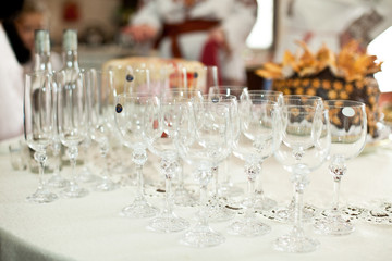 Empty wineglasses stand on the white dinner table