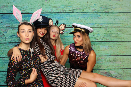 S&uuml;&szlig;e M&auml;dchen mit Kopfbedeckungen vor einer Fotobox - party mit Photobooth