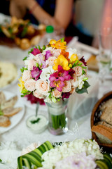 White and pink wedding bouquet stands on the rich dinner table
