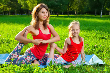 Mother and her daughter outdoors doing yoga