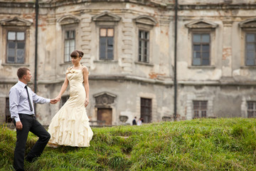 Gorgeous lady in evening gown walks down on the green hill