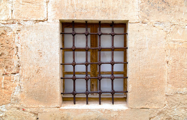 Fototapeta na wymiar Старый песчаник стены с окном и решеткой