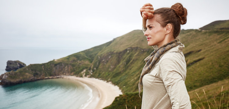 woman looking into distance in front of ocean view landscape
