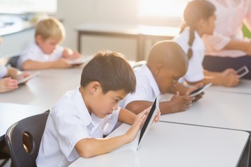 School kids using digital tablet in classroom
