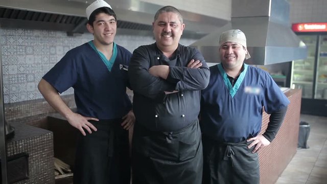 The team of chefs with chef smiling at the camera.
