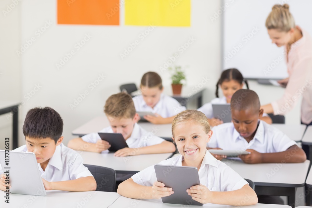 Poster students using digital tablet in classroom