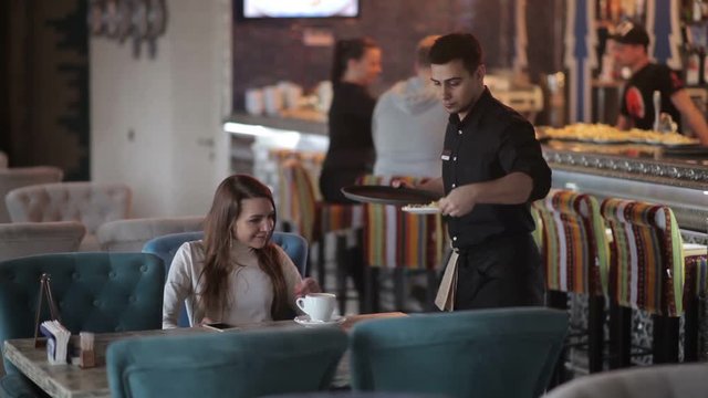 A young woman brings order in a restaurant.