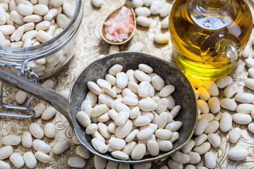 Raw white beans and a metallic ladle
