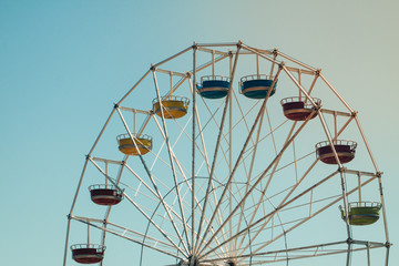 Vintage colorful ferris wheel over blue sky