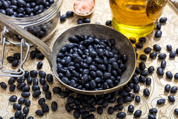 Raw black beans and a metallic ladle