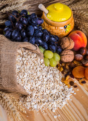 oatmeal in a sac, dried apricots, raisins, grapes, nuts on the b