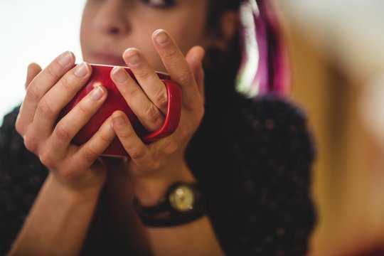 Cropped image of woman having coffee