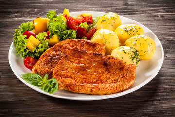 Fried chicken fillets, boiled potatoes and vegetable salad