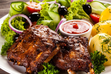 Grilled ribs, French fries and vegetables on white background 