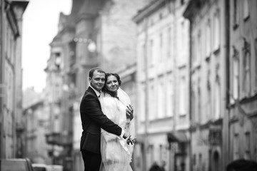 Black and white picture of a gracious wedding couple standing on