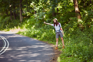 Worried young woman hitch hiking