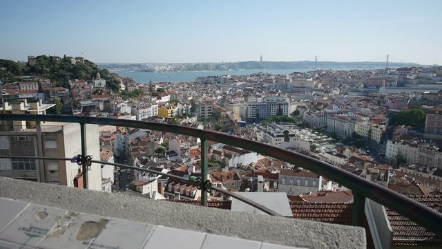 A dolly shot of Lisbon cityscape from Miradouro Senhora do Monte, with a map of the city made of tiles in the foreground.