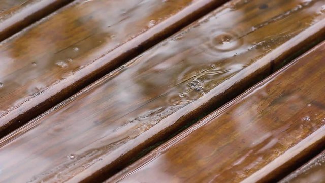 Pingos de chuva no deck de madeira.