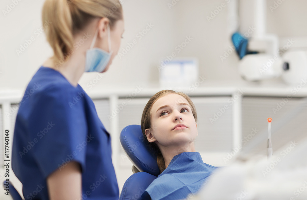 Sticker happy female dentist with patient girl at clinic