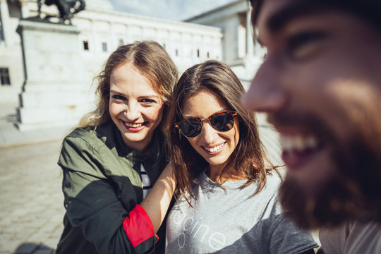 Austria, Vienna, three friends having fun in front of the parliament building