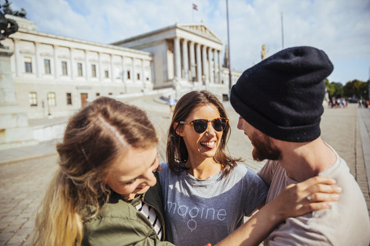 Austria, Vienna, three friends having fun in front of the parliament building