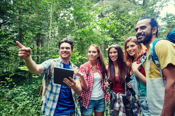 happy friends with backpacks and tablet pc hiking
