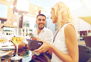 happy couple with wallet paying bill at restaurant